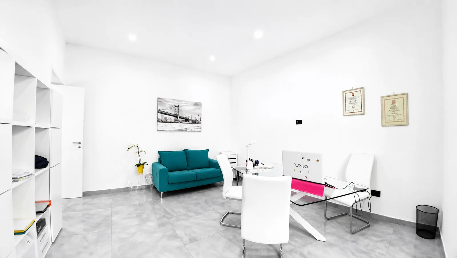 Studio con scrivania in vetro e divano